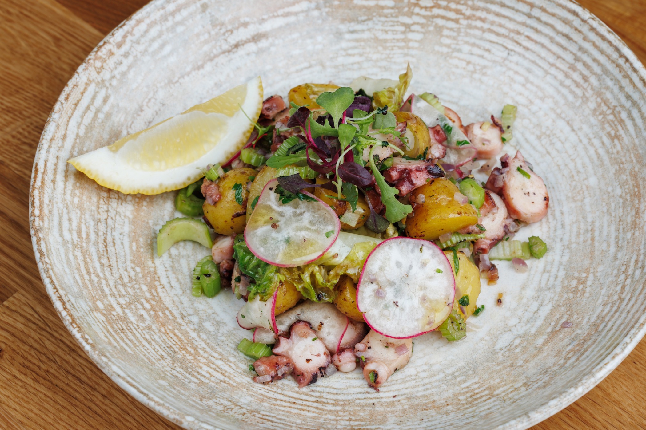 Insalata di mare con patate, sedano, olive ed erbe aromatiche